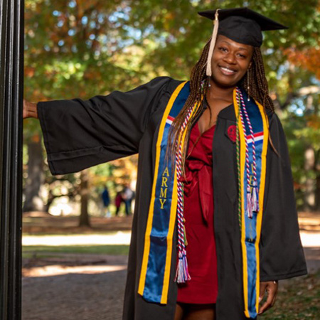 BAIS graduate Synithia Weaver poses for a photo on the USC campus wearing her cap and gown.