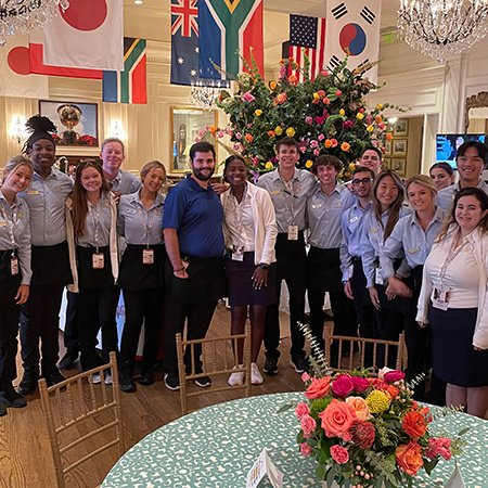 A large group of HRTM students pose for a photo at Quail Hollow, host site for the 2022 President's Cup.