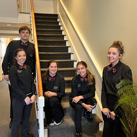 Five students pose for a photo at McCutchen House.