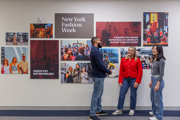 Three students converse in the Department of Retailing lobby