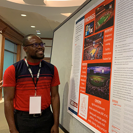Ph.D. student Kemardo Tyrell looks at a research presentation at the 2022 College Sport Research Institute Conference.