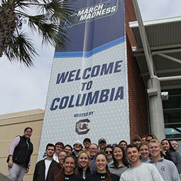 Haylee Mercado poses with her class outside the Colonial Life Arena, host to the NCAA March Madness Basketball Tournament.