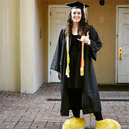 Tara Parker in her cap and gown with her Cocky feet on
