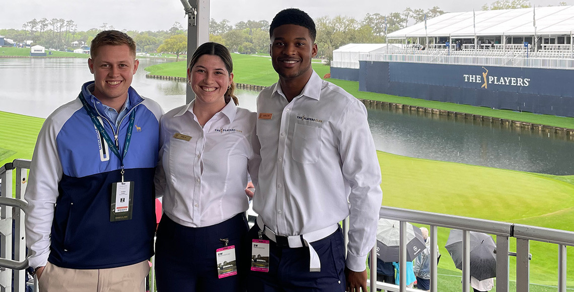 Three HRTM students pose for a photo at the Players Championship in March 2022.