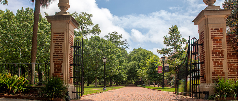 the entrance to the historic horseshoe, with the gates open and the brick walkway leading in.