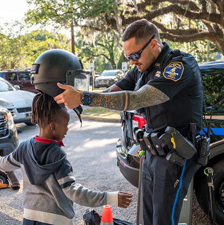 Officer putting helmet on child