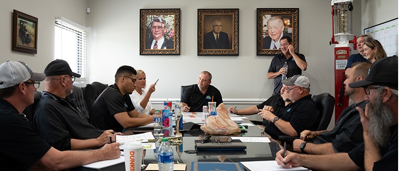 Employees of Chase Oil sitting around a table discussing