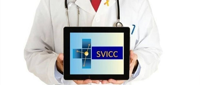 Doctor in white lab coat holding computer tablet with SVICC on the screen.