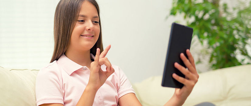 A girl practices signing with her tablet