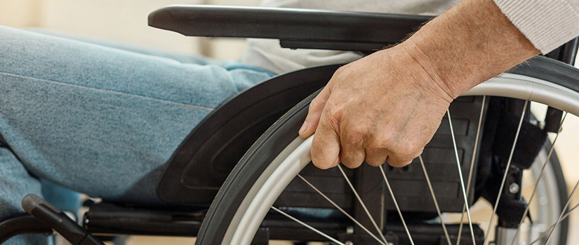 Close up photo of hands moving a wheelchair