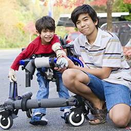 Older brother with younger brother in an assistive walker