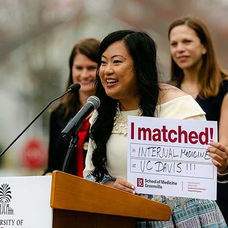 Excited student at podium shows her residency match