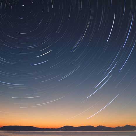 Stars form a circular pattern in the sky at dusk.
