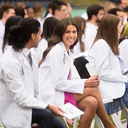 Med students sit in rows outside during the white coat ceremony