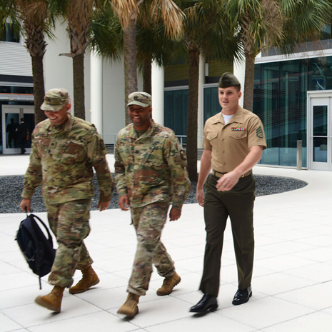 Men in military uniforms walking through Moore School courtyard