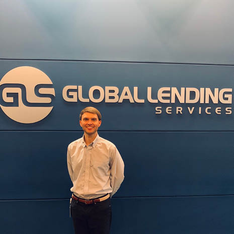 Image of Matt Pangle in front of a Global Lending Services LLC sign