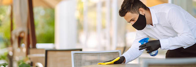 Banner Image of someone cleaning a table as a COVID-19 precaution