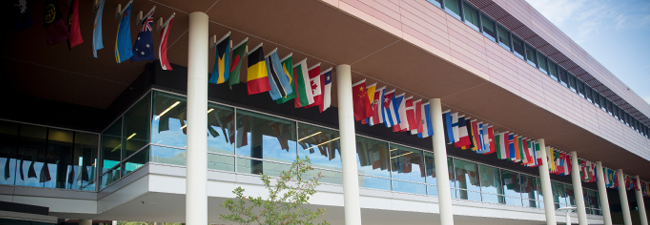Banner Image of the international flags on the side of the Moore School building