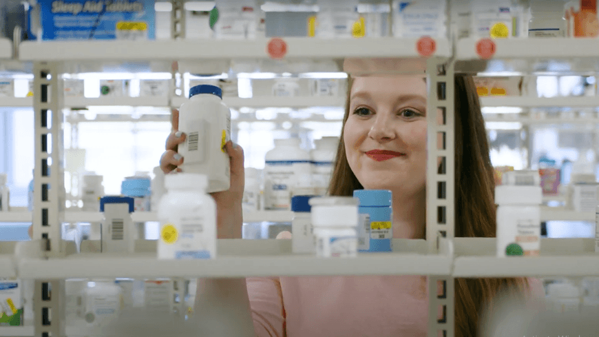 Pharmacist looking at shelves with medications