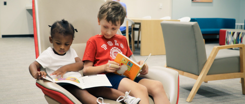 Two kids seated reading books