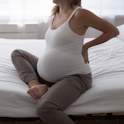 pregnant woman sitting on bed