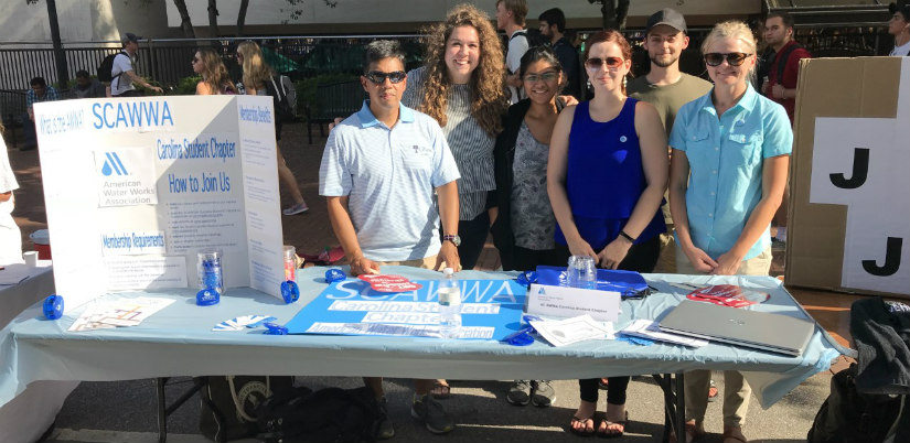Students in the student chapter for the American Water Works Association standing in front of a table