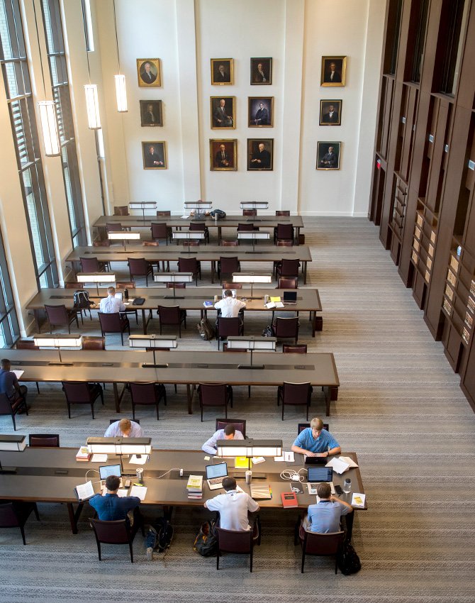 Students studying in the Coleman Karesh Reading Room with portraits haning on the wall