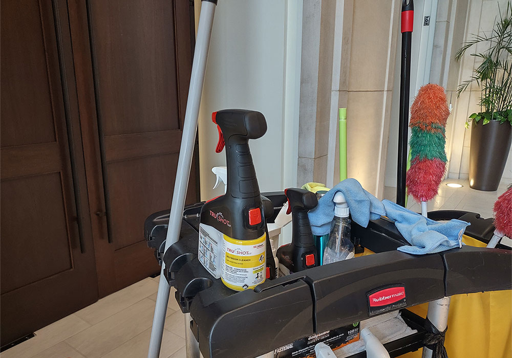 The TruShot cleaning cartridge in its spray bottle on a custodian's cart