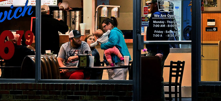 view through a diner window of a family of four sitting at a table