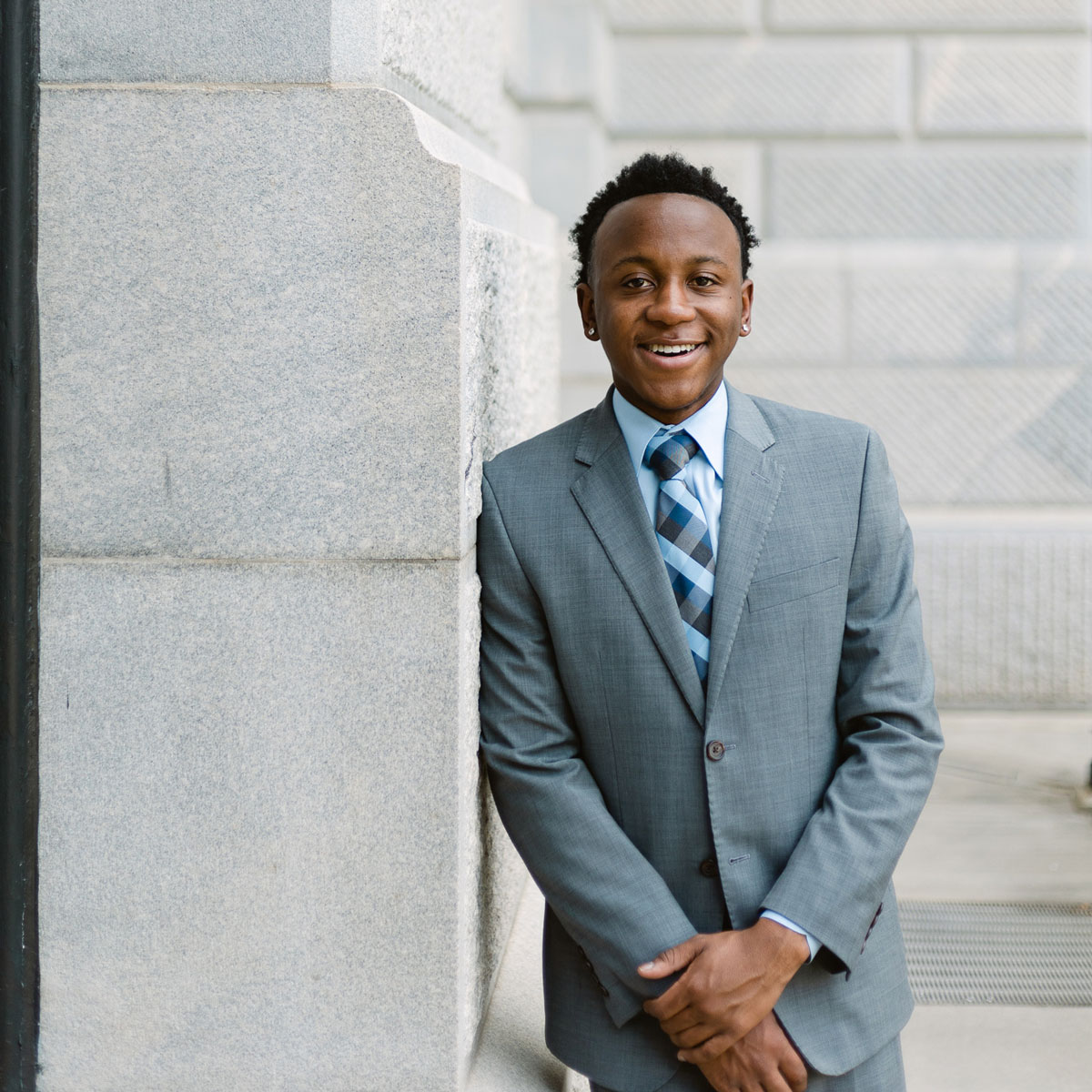 Man leaning against a wall smiling