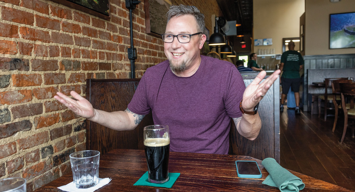 Ray McManus converses with Carolinian in a restaurant over a beer.