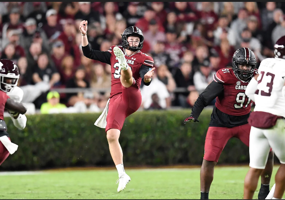 Kai Kroeger kicks a punt during a game.