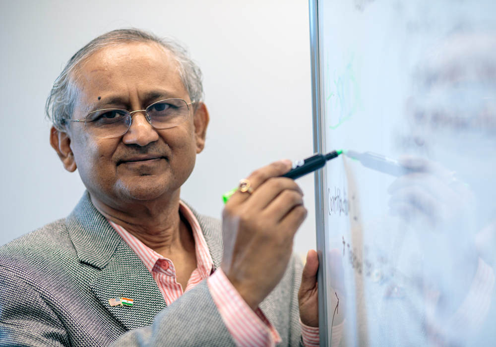 Amit Sheth stands at a white board with a marker