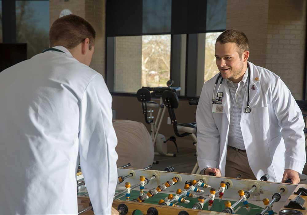 School of Medicine Greenville student plays foosball in student lounge.