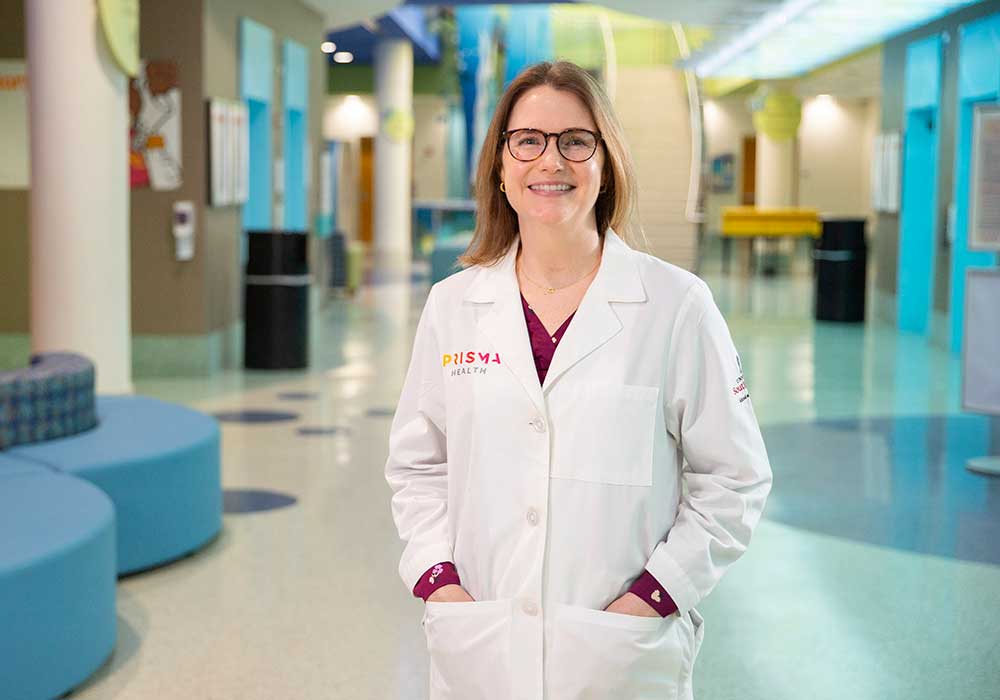 USC professor and alumna Anna Hoppmann stands in the atrium of Prisma Health's Children's Hospital.