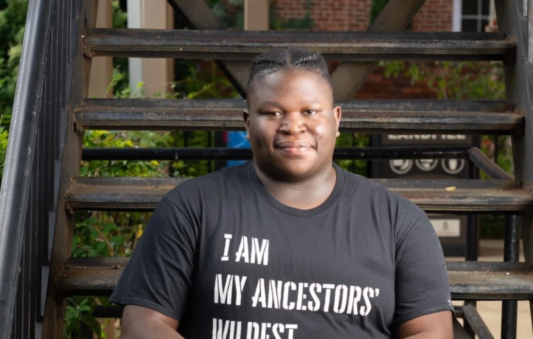 C.J. Owens wearing a shirt that says "I am my ancestors' wildest dreams."