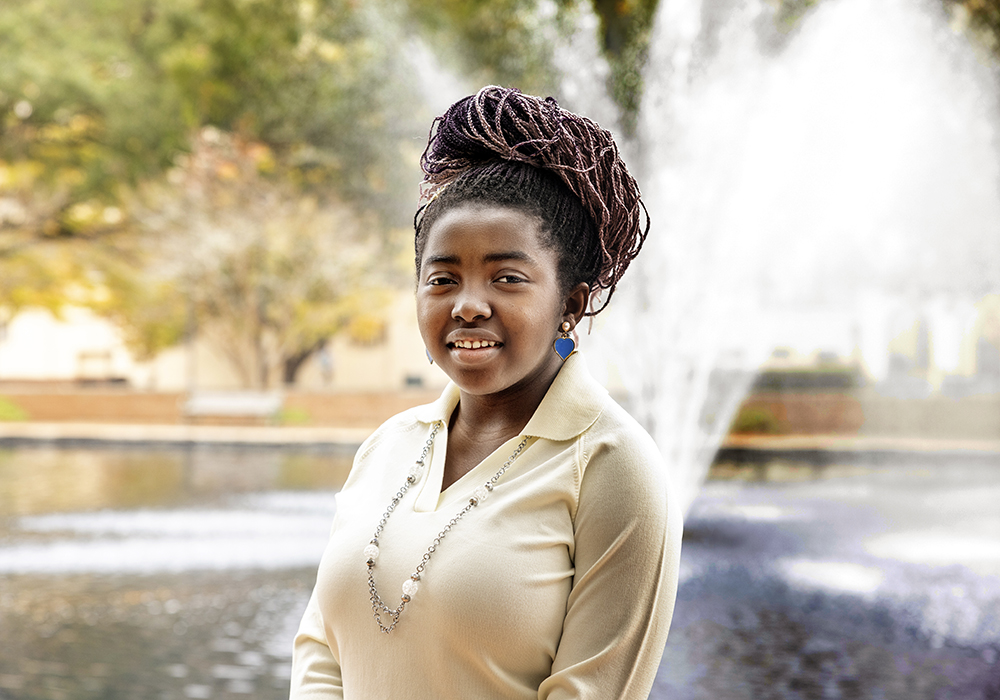 Korebami Adebajo stands in front of the fountain at USC's Thomas Cooper Library.