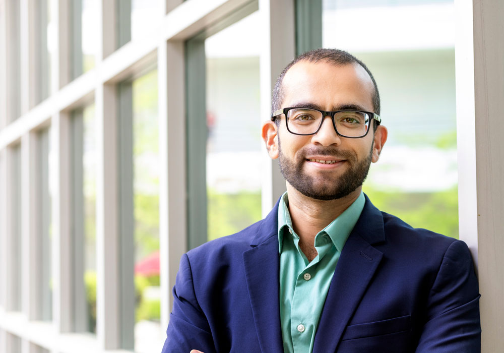 man stands in front of a wall of windows