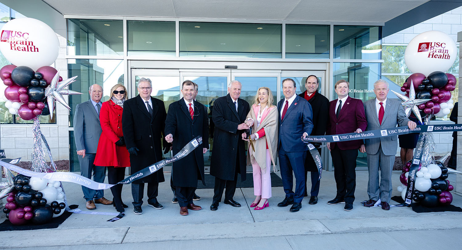 University and South Carolina leadership cut a “USC Brain Health” ribbon outside the Brain Health Center, flanked by garnet, black and white balloons.