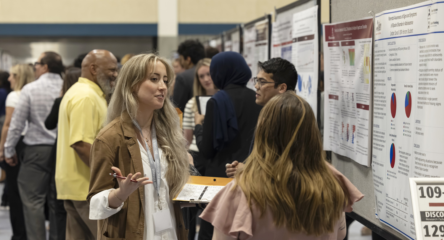 A presenter talks with an attendee at Discover USC.