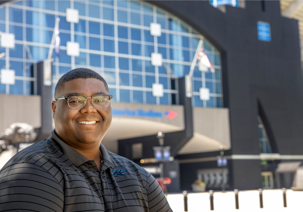 Alex Grant stands in front of Bank of America stadium in Charlotte.