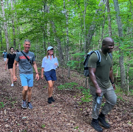 People hiking through densely wooded area