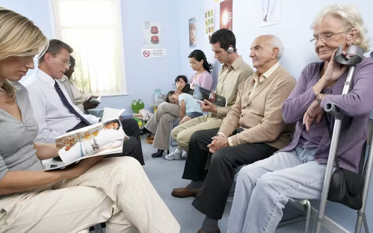 A variety of patients await treatment in a waiting room.