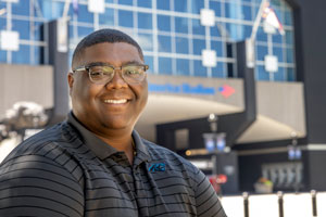 Alex Grant stands in front of Bank of America football stadium