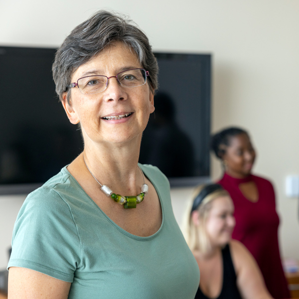 head and shoulders of angela liese with students in the background