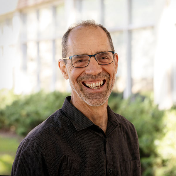 Carbone smiles broadly outside a building on campus.