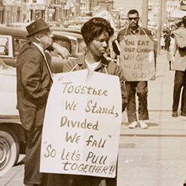 Two people with signs around their necks protesting segregation