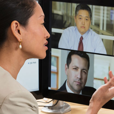 woman in front of computer screen videoconferencing with co-workers