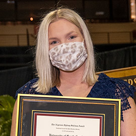 Issy Rushton holding her framed Sullivan award. 