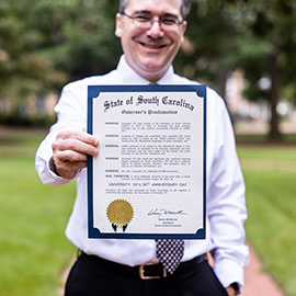 Dan Friedman holds a physical copy of the governor's proclamation on the Horseshoe